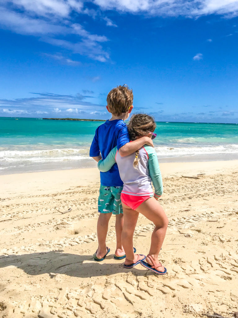 Son and daughter hugging on the beach of Oahu