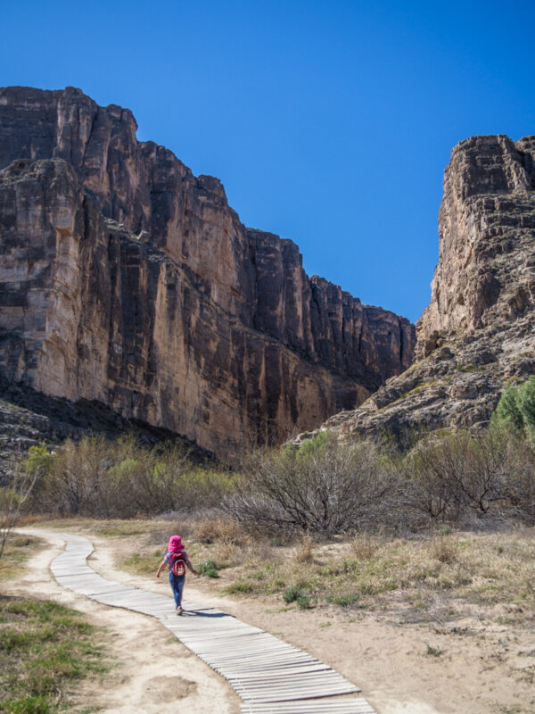 Young girl in pink hat hiking in Santa Elena Canyon, Big Bend National Park, Texas