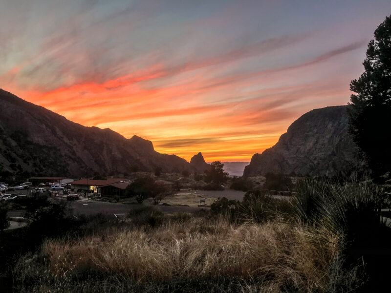 Orange and pink sunset over the Chisos developed area in Big Bend National Park, with Chisos mountains in the background