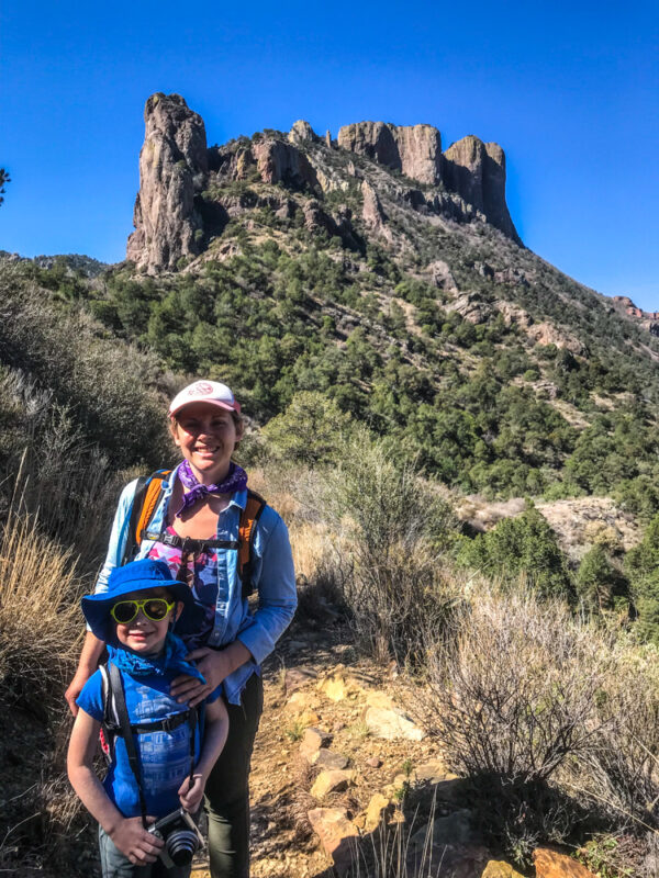 Mother and son hiking in Big Bend National Park showing off what to pack for Big Bend, mountain in background