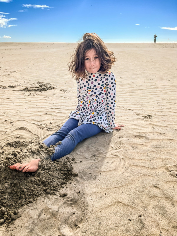 things to do in San Diego with kids - Coronado Island beach - young girl sitting in the sand