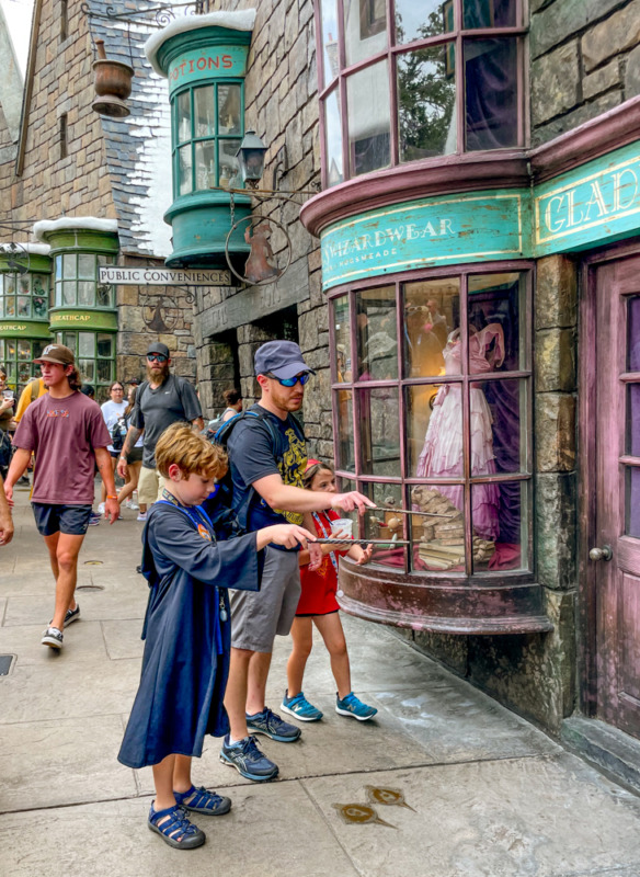 Family casting spells in Diagon Alley at Wizarding World of Harry Potter Orlando with tweens