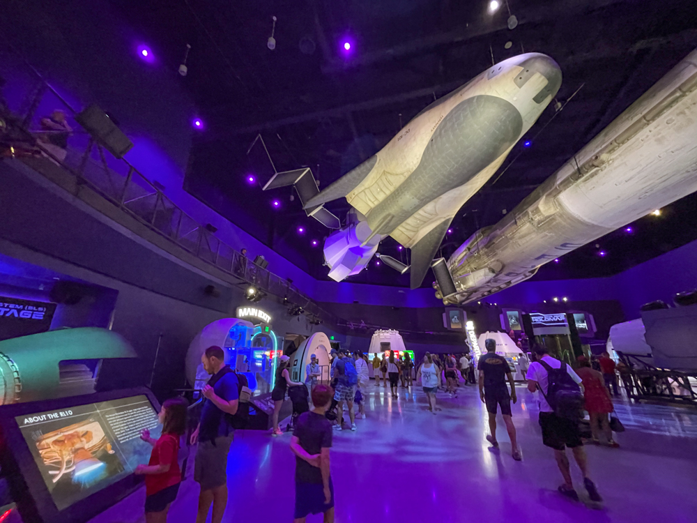 Purple-lit room with spacecraft at Kennedy Space Center with tweens