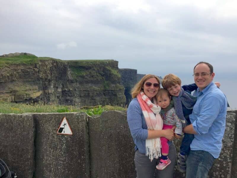 Renting a car in Ireland is the ideal way to explore, especially if you're on a family trip to Ireland or prefer to set your own schedule as shown in this family photo at the Cliffs of Moher.